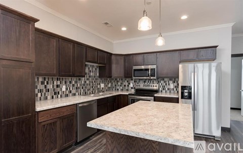 A kitchen with dark wood cabinets and a marble countertop.