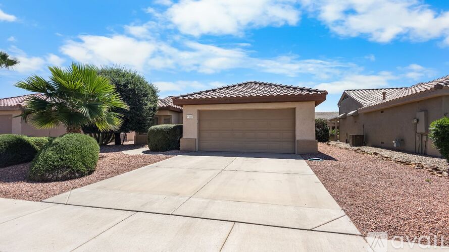 A house with a garage and a driveway in front of it.