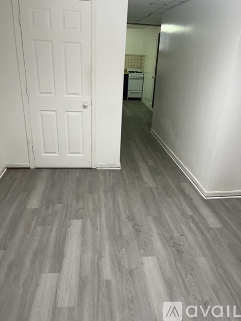A room with a white door and a wooden floor.