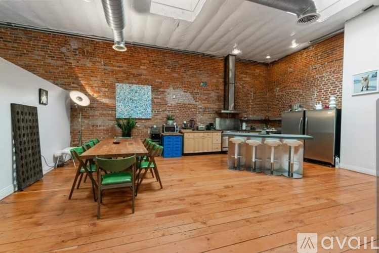 A kitchen with a wooden table surrounded by chairs.