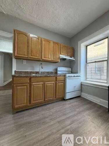 A kitchen with wooden cabinets and a white dishwasher.