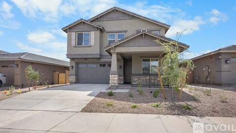 A modern house with a large front yard and a driveway.
