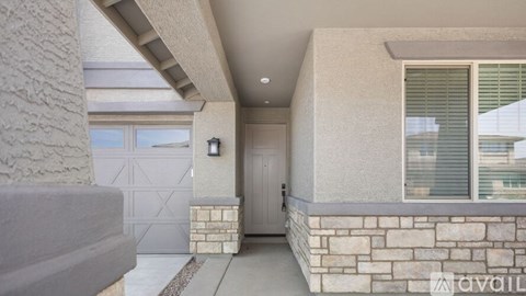 A house entrance with a stone wall and a white door.