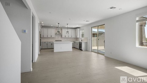 A spacious kitchen with white cabinets and a large island in the middle.