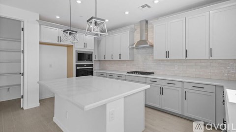 A modern kitchen with white cabinets and a large island.