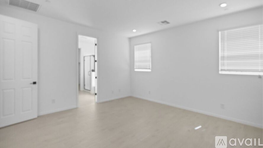 A spacious empty room with a door and a window.