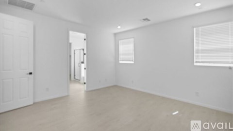 A spacious empty room with a door and a window.