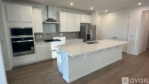 A kitchen with white cabinets and a large island.