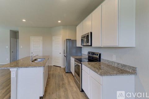A kitchen with white cabinets and a granite countertop.