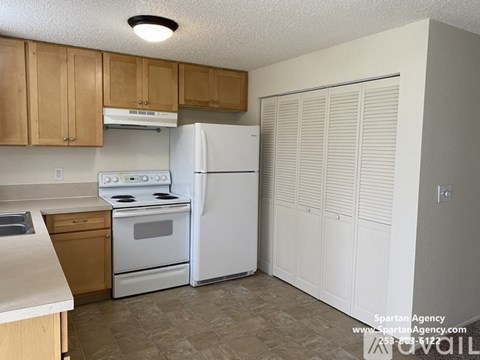 A kitchen with a white refrigerator and white stove top oven.