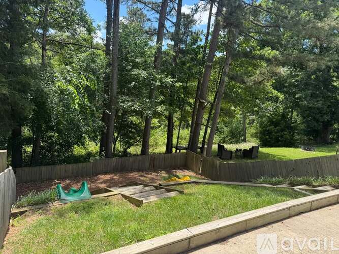 A backyard with a wooden fence and a green lawn chair.