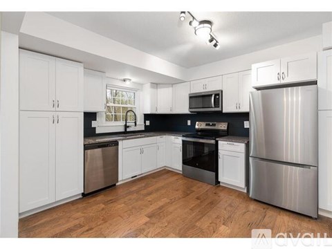 A kitchen with white cabinets and stainless steel appliances.