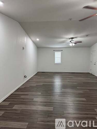 A room with wooden flooring and a ceiling fan.