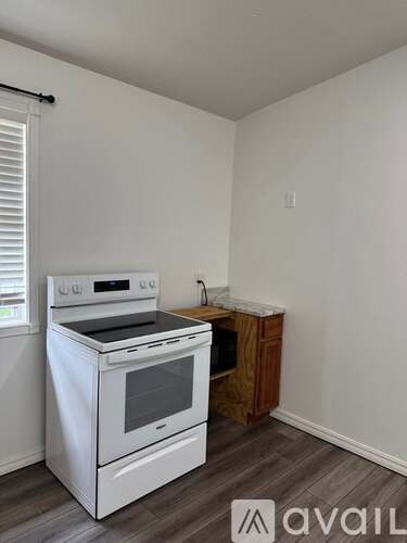 A white stove is in a room with a wooden cabinet.