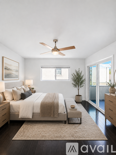 A bedroom with a large bed and a ceiling fan.