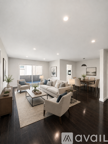 A living room with a white couch and a glass coffee table.