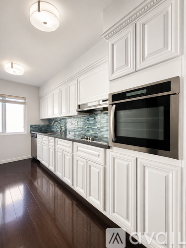 A kitchen with white cabinets and a black oven.