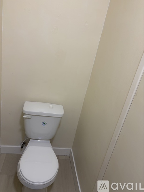A white toilet with a white tank and lid in a bathroom.