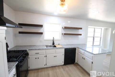 A kitchen with white cabinets and a black stove top oven.