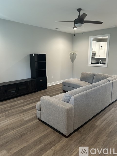 A living room with a grey couch and a black cabinet.