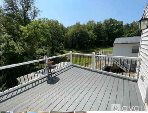 A wooden deck with a table and chairs overlooking a green landscape.