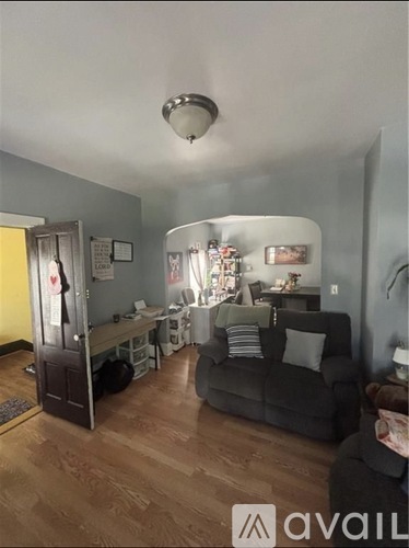 A living room with a grey couch and a wooden floor.
