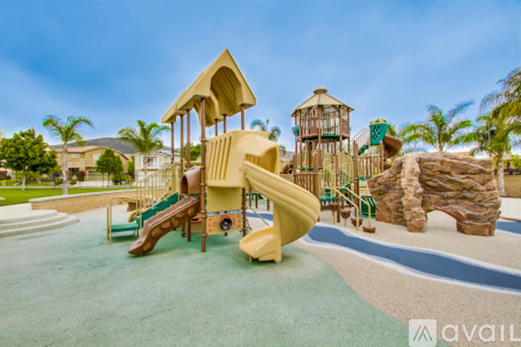 A playground with a yellow slide and a green slide.