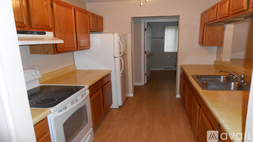 A kitchen with wooden cabinets and a white refrigerator.