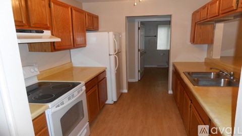 A kitchen with wooden cabinets and a white refrigerator.