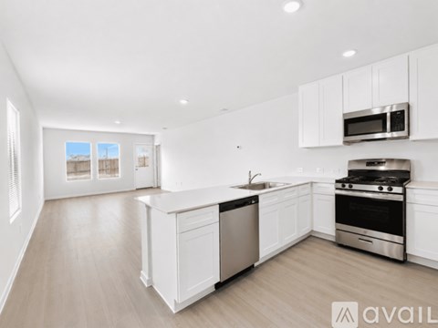 A modern kitchen with white cabinets and stainless steel appliances.