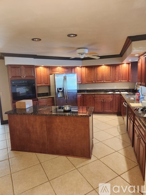 A kitchen with wooden cabinets and a granite countertop.