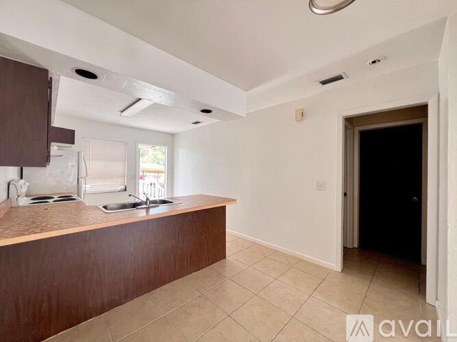 A kitchen with brown countertops and white walls.
