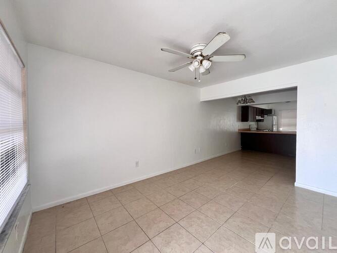 A room with a ceiling fan and tiled flooring.