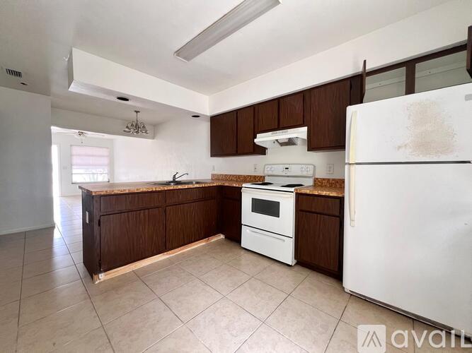 A kitchen with brown cabinets and white appliances.