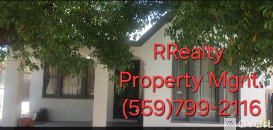 A sign for RRealty Property Management with a phone number is displayed.