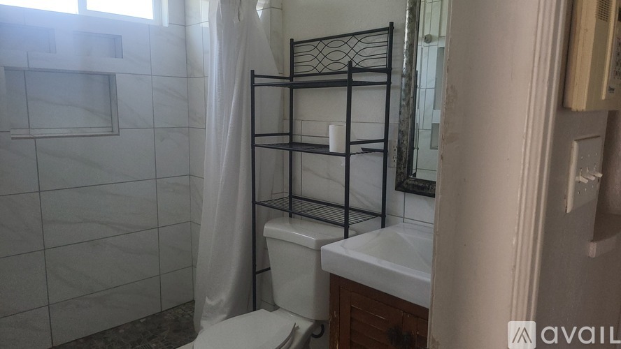 A bathroom with a toilet, sink, and a shower curtain.