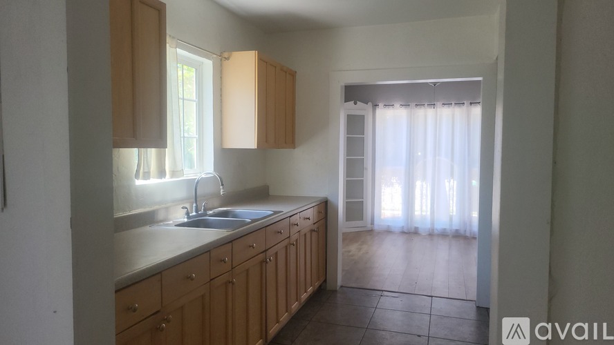 A kitchen with wooden cabinets and a sink under a window.