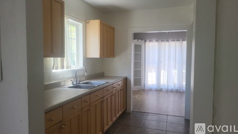 A kitchen with wooden cabinets and a sink under a window.