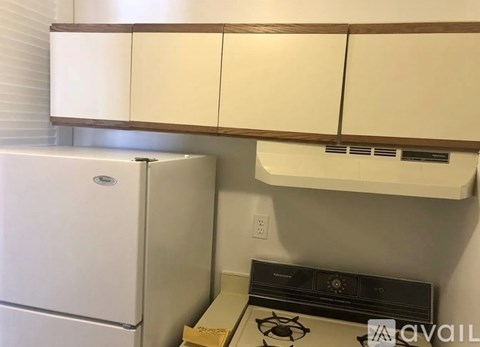 A white fridge and a black stove in a kitchen.