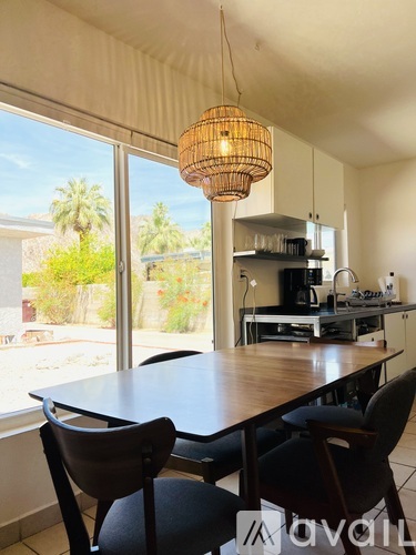 A kitchen with a table and chairs in front of a window.
