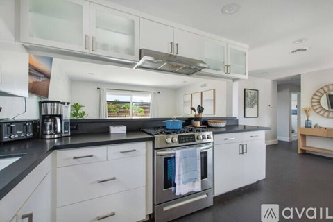 A modern kitchen with white cabinets and a stainless steel oven.