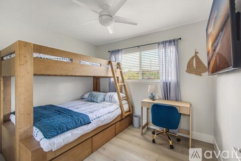 A bedroom with a bunk bed and a desk.