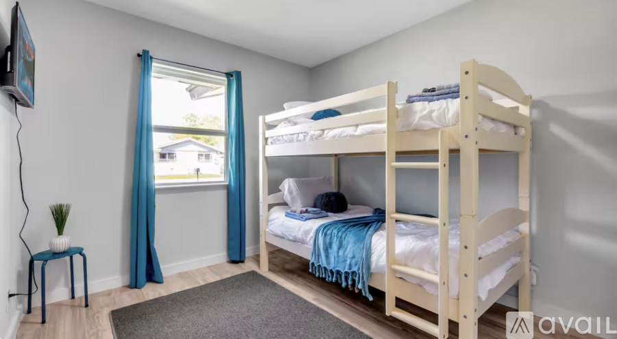 A room with two bunk beds and a small table.