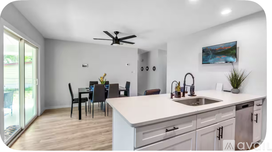 A kitchen with a dining table and chairs.