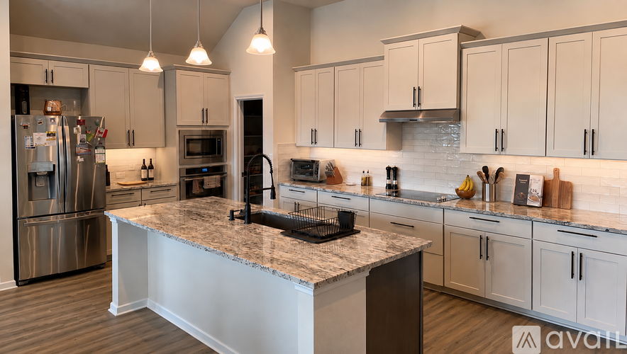 A kitchen with a marble countertop and stainless steel appliances.