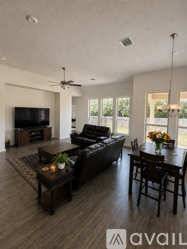 A living room with a black leather couch and a wooden coffee table.