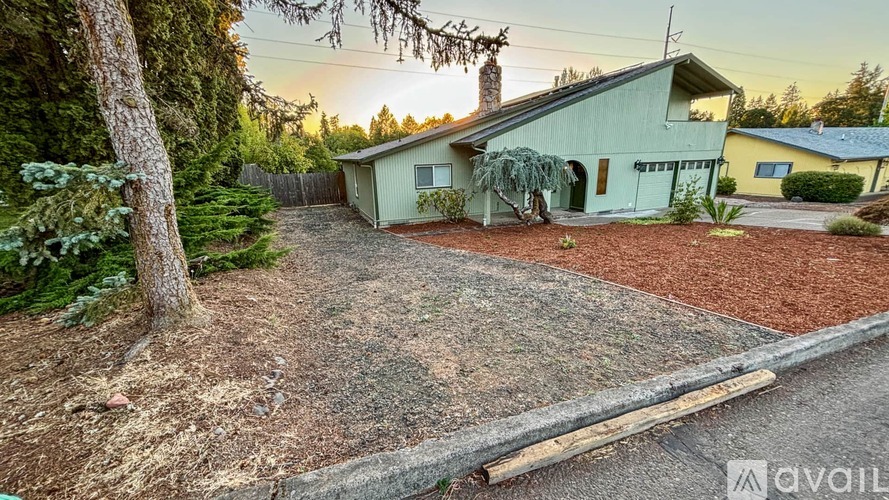 A house with a green lawn and a tree in front of it.