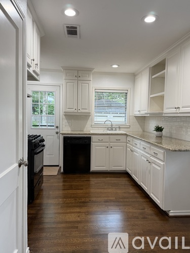 A kitchen with white cabinets and a black stove top oven.