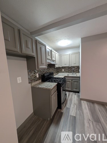 A kitchen with a granite countertop and wooden flooring.