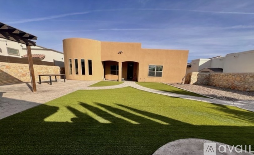 A modern building with a curved wall and a green lawn in front.